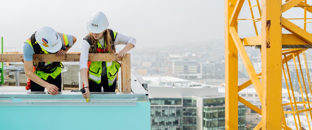 Two engineers working on a rooftop.