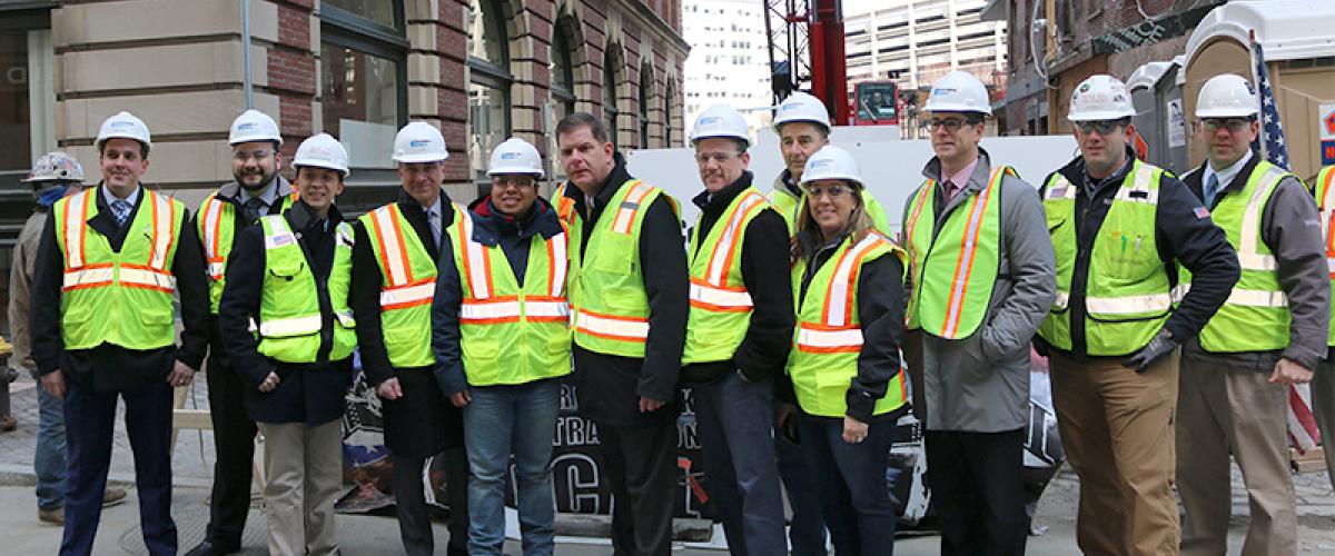 Image of Walsh Brothers employees in construction gear celebrating topping off milestone at Boston Greenway's new residential building