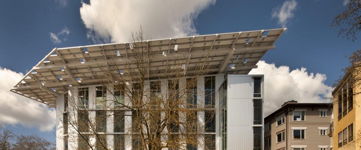 A low-angle view showcasing its prominent overhanging solar array roof and large glass windows.