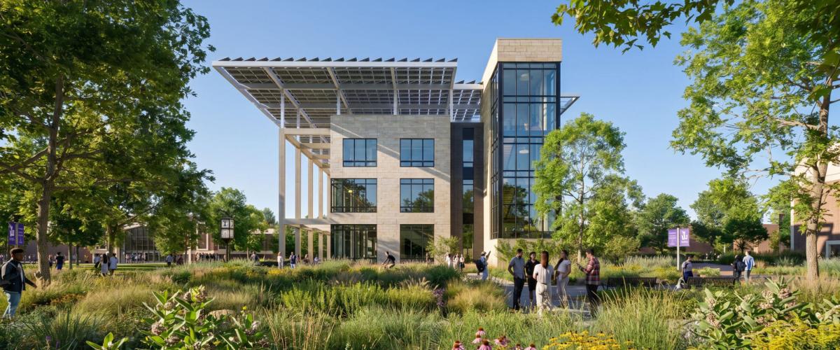 A contemporary academic building with large glass windows and a prominent solar array, surrounded by green spaces and mature trees.