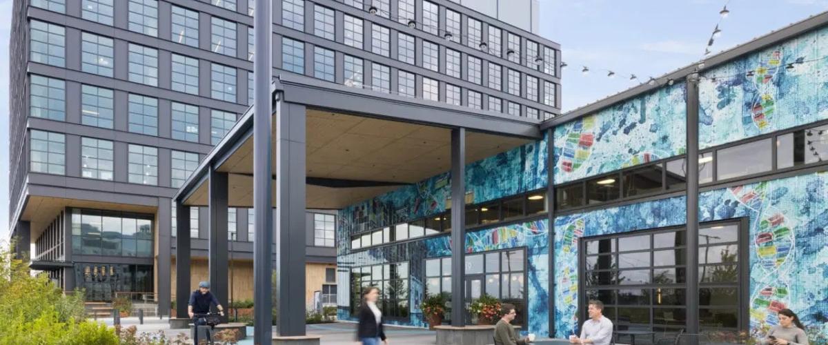 Exterior of the warehouse looking structure featuring a overhang matching the new construction and a colorfully painted mural facade