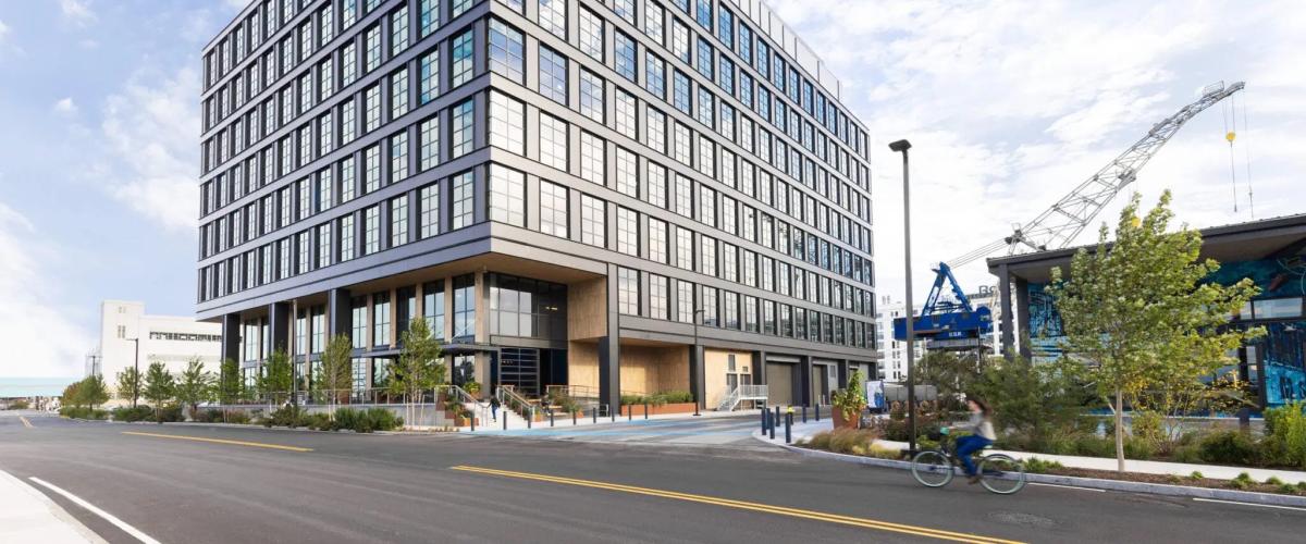 External view of the eight story building highlighting its dark metal and glass industrial aesthetic