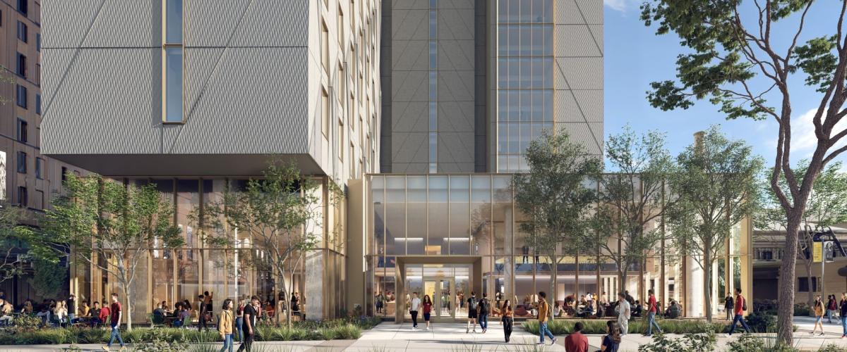 A modern multi-story building featuring a textured, geometric facade above a transparent, glass-enclosed ground floor with prominent structural columns.