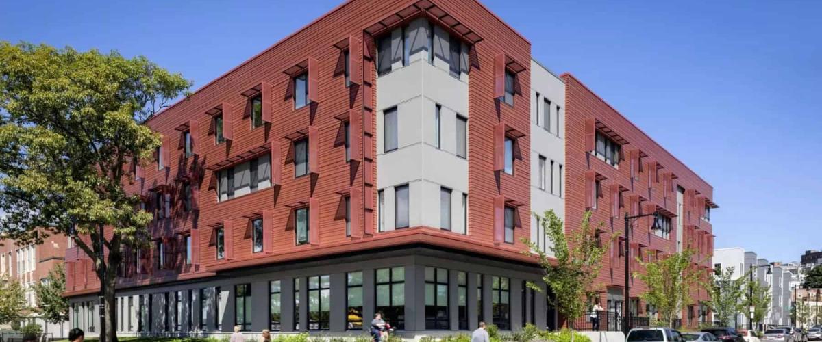 Pedestrians walk past the corner of the Old Colony housing development.