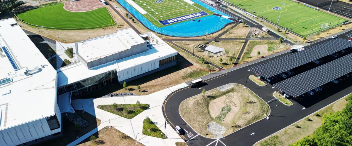 Aerial view of Stoneham High School of sports fields and solar EV parking lot