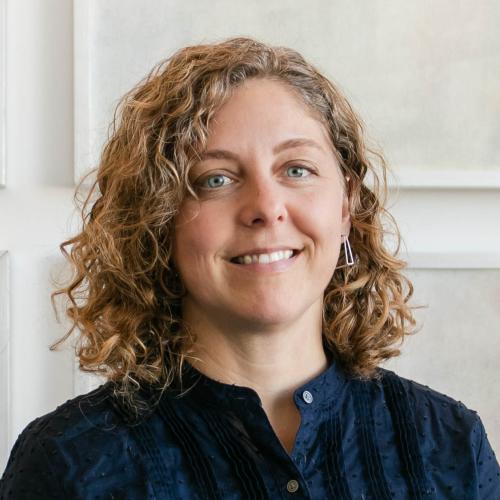 Photo of blondish brown curly hair middle aged woman.