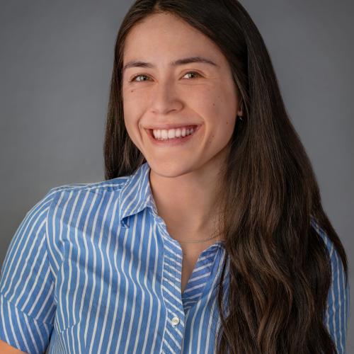 Asian woman with long brown hair and a blue and white striped button-down. 