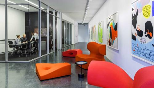 Interior hallway of Elkus' offices. People can be seen working inside a glass walled room.