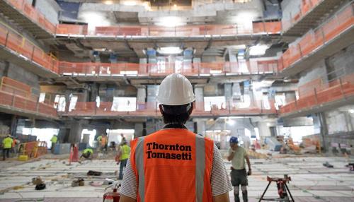 Man looking out at worksite wearing Thornton Tomasetti work vest