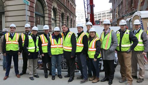 Image of Walsh Brothers employees in construction gear celebrating topping off milestone at Boston Greenway's new residential building