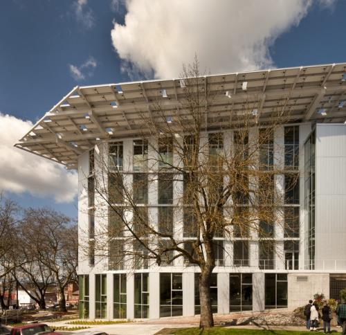 A low-angle view showcasing its prominent overhanging solar array roof and large glass windows.