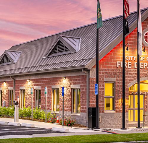 Exterior corner of the building featuring a pitched room and red brick colored stone unit facade