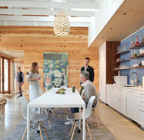 A bright, contemporary kitchen and dining area defined by clean lines, natural wood accents, and ample natural light.