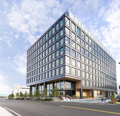 External view of the eight story building highlighting its dark metal and glass industrial aesthetic
