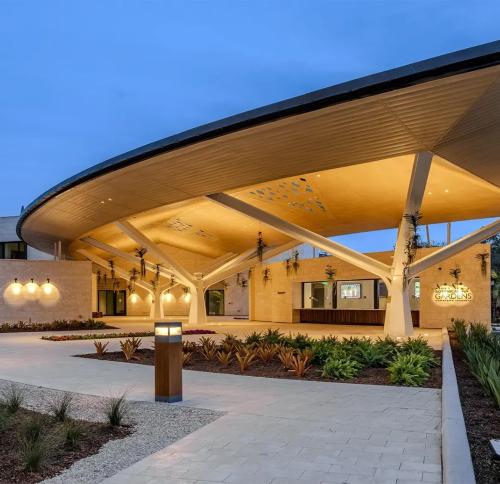 The entrance to Marie Selby Botanical Gardens, showcasing contemporary architecture with a distinctive, sweeping roofline and surrounding landscaping.
