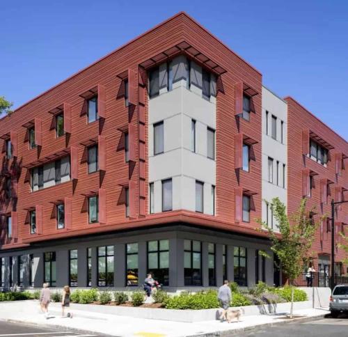 Pedestrians walk past the corner of the Old Colony housing development.